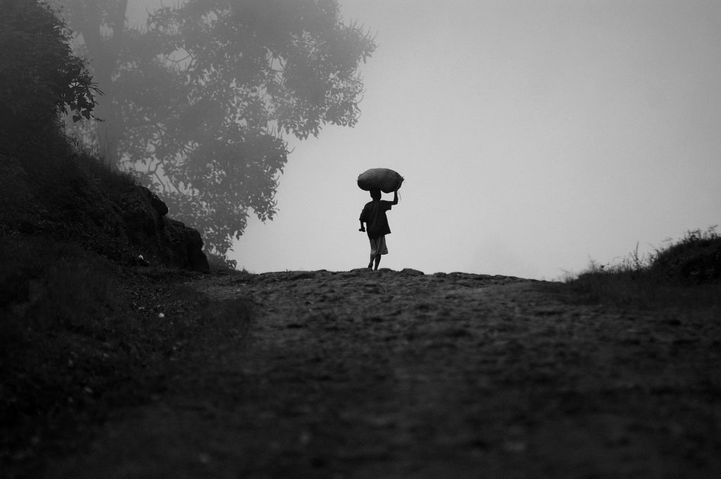 Black and White photo of child carrying load